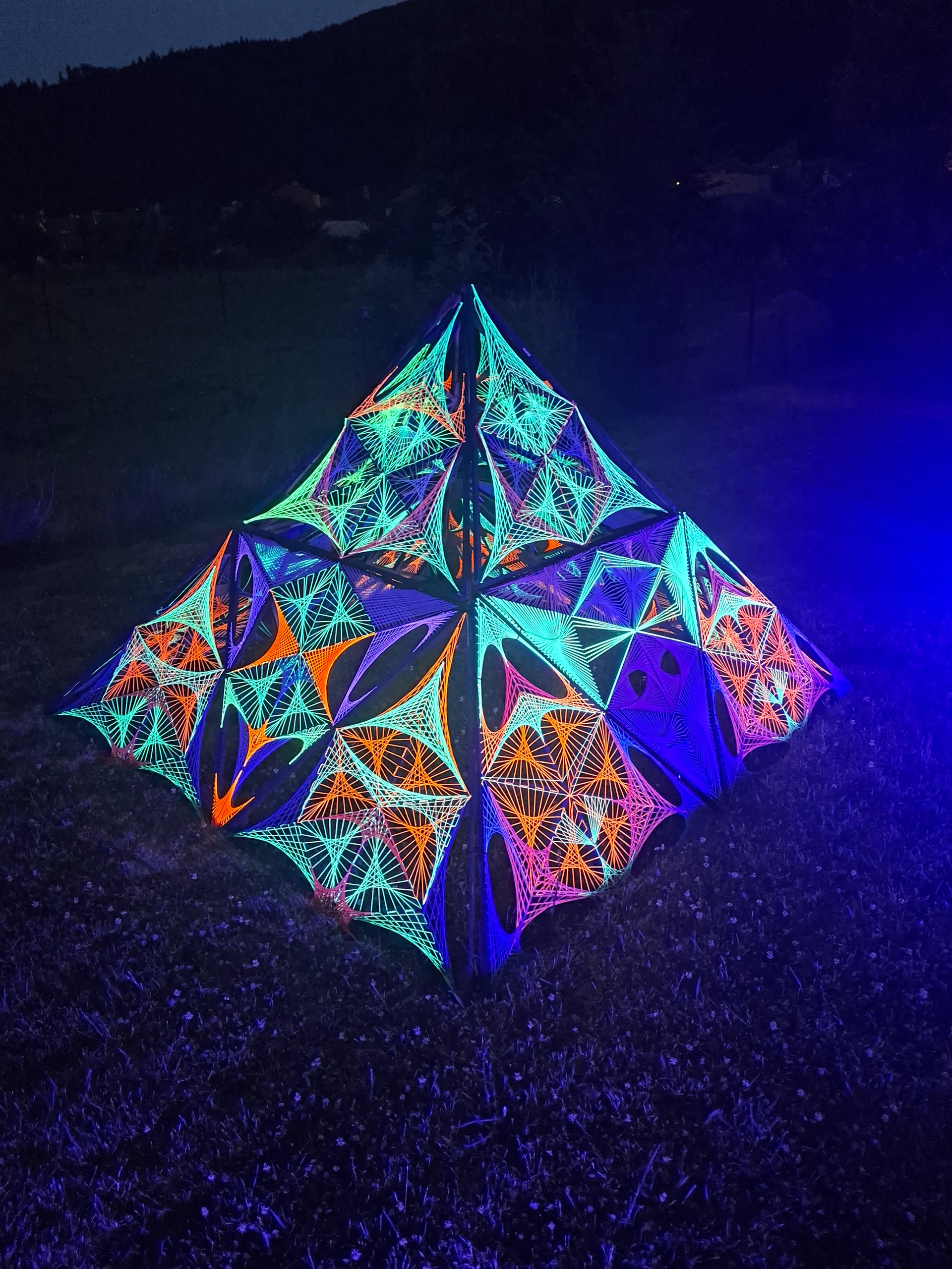 Load video: Building a 3D UV pyramid together at the Digital Forest festival (CZ) ✨A creative process where people, space and psychedelic visuals merge into one experience.From individual string art elements to a living festival installation 🌲