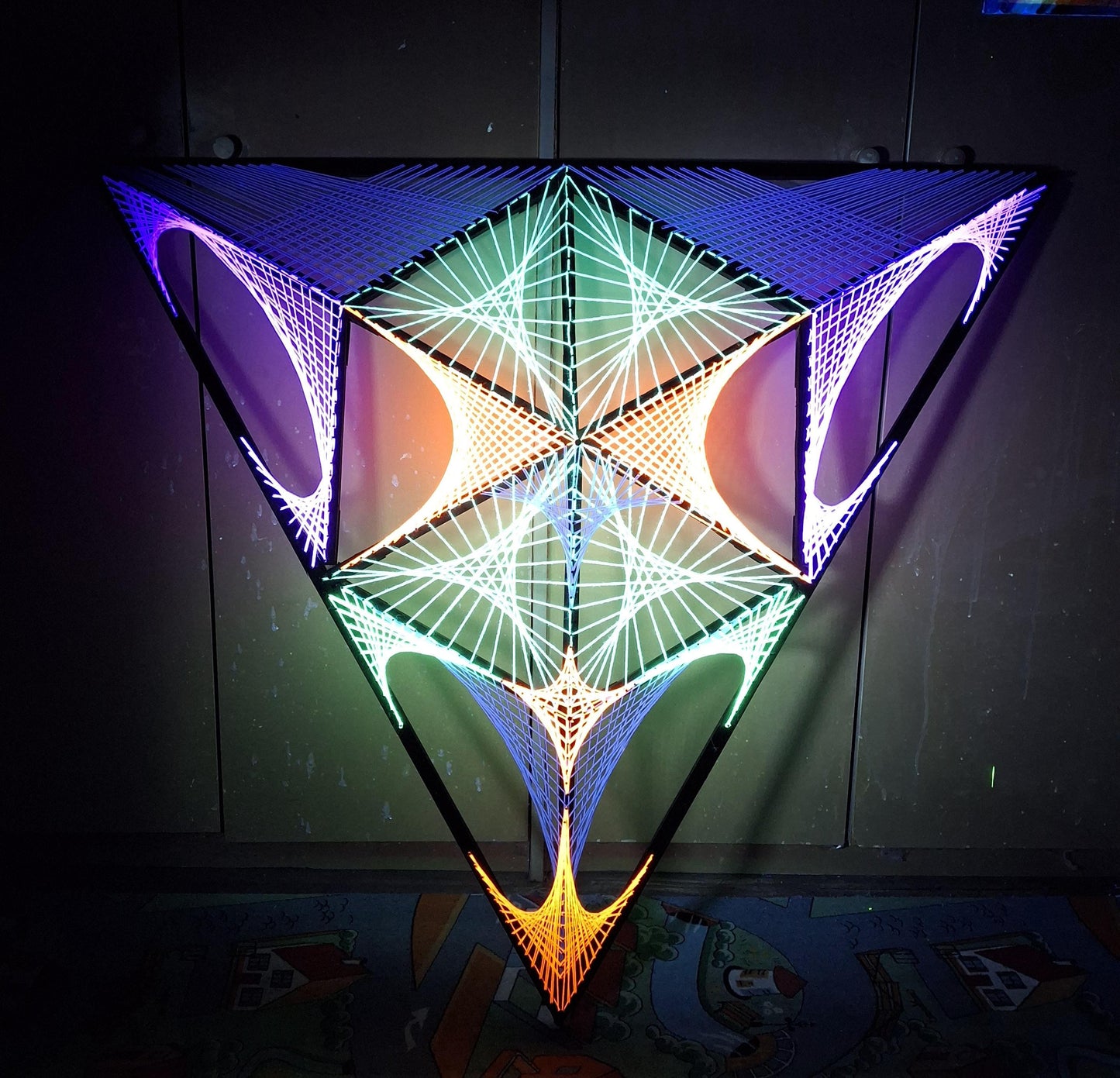 handmade UV reactive string art artwork with alien motif, geometric structure, glowing under ultraviolet light, by Psybell - from Slovakia
