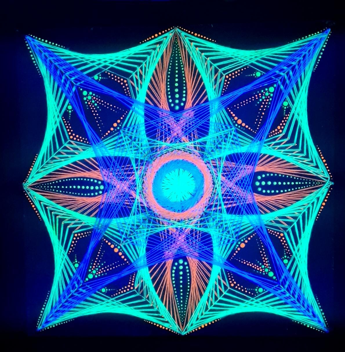 handmade UV reactive string art mandala “Aura Flow” glowing under ultraviolet light, geometric dotted pattern created with nails and threads on wooden board, psychedelic wall art by Psybell