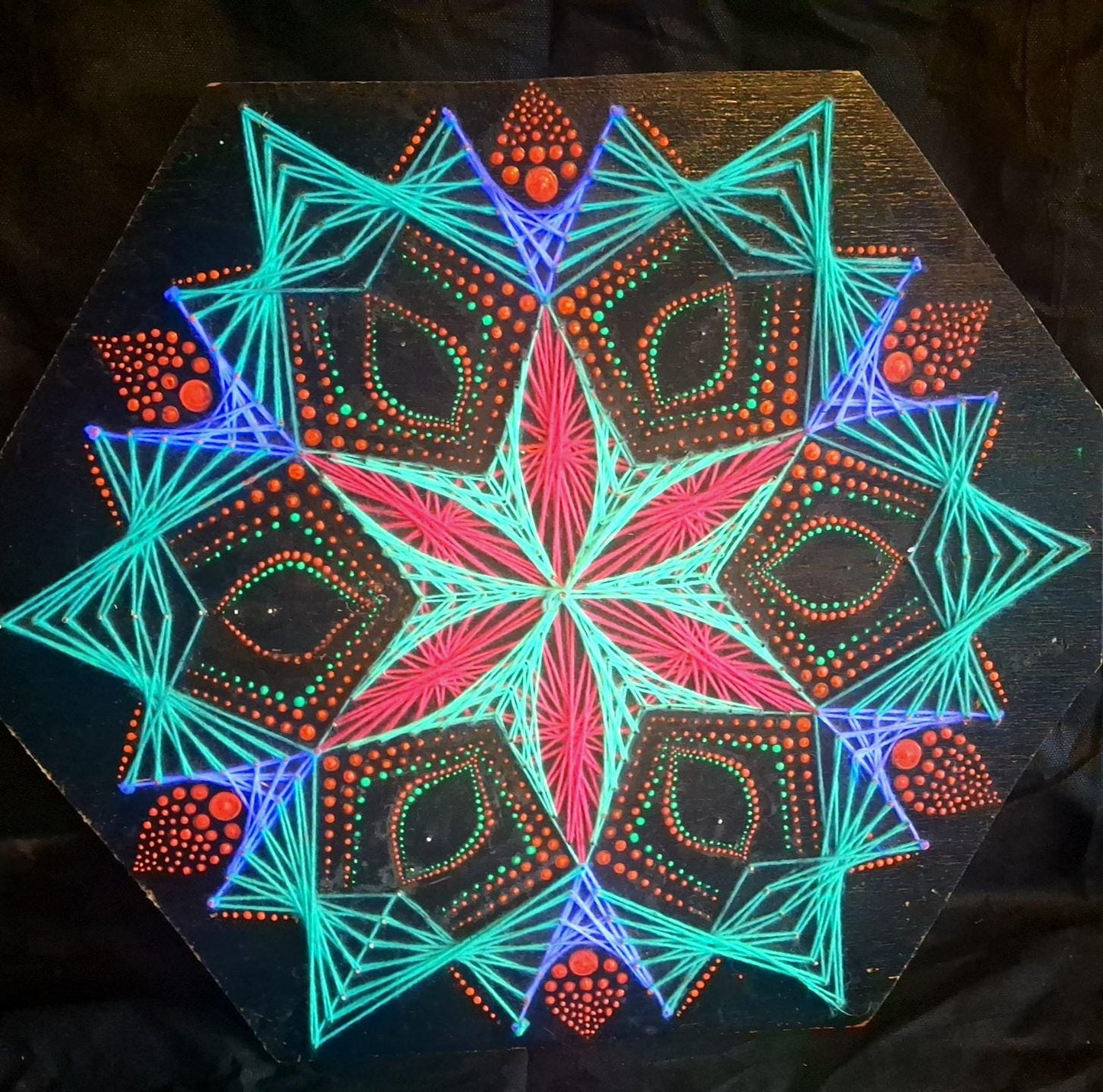 Blooming Anise detail, UV reactive dotted mandala string art, close-up of glowing dots and threads on wood, handmade Psybell artwork