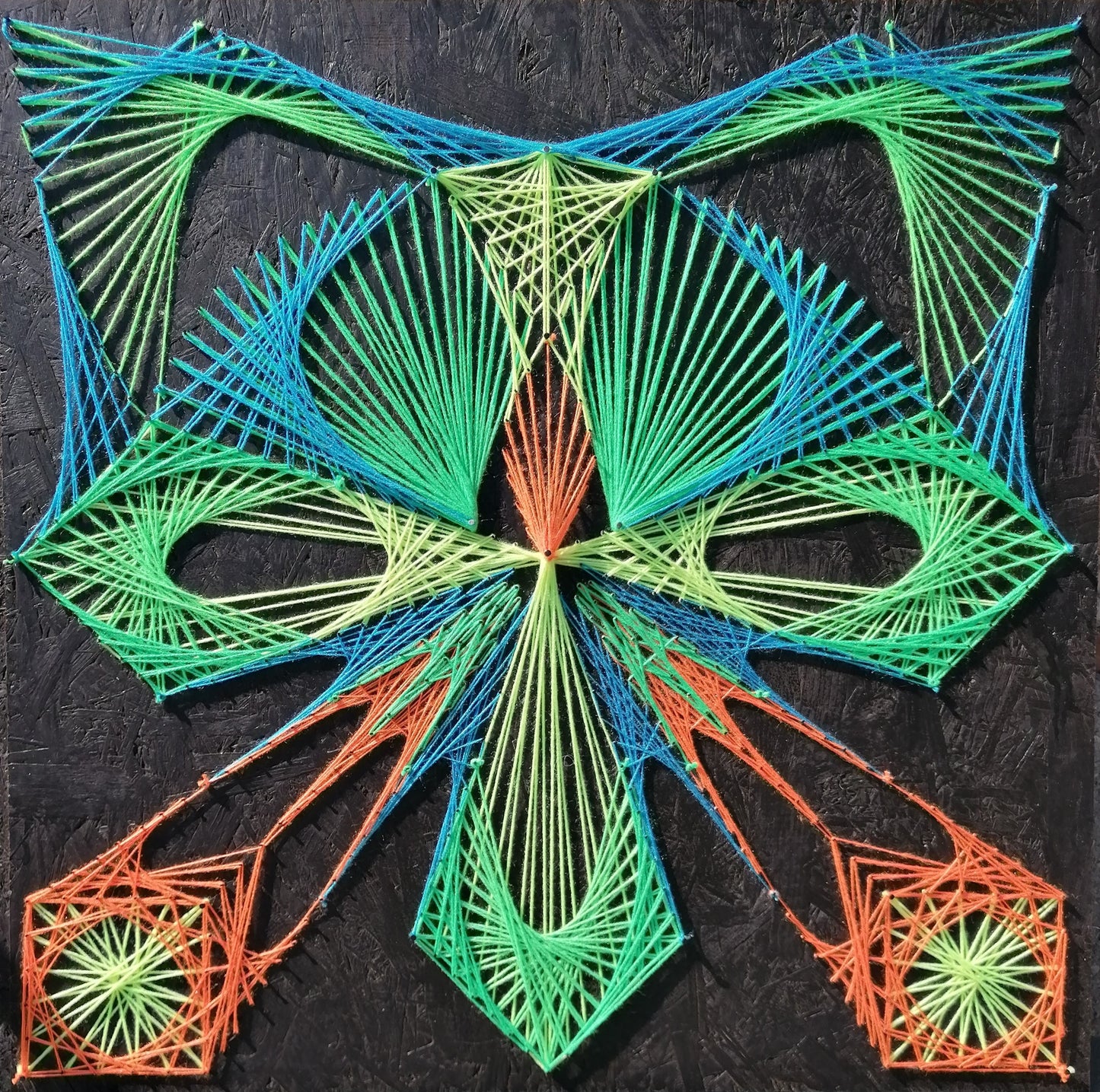 handmade string art cat with symmetrical geometric pattern, multicolor threads on dark background, by Psybell
