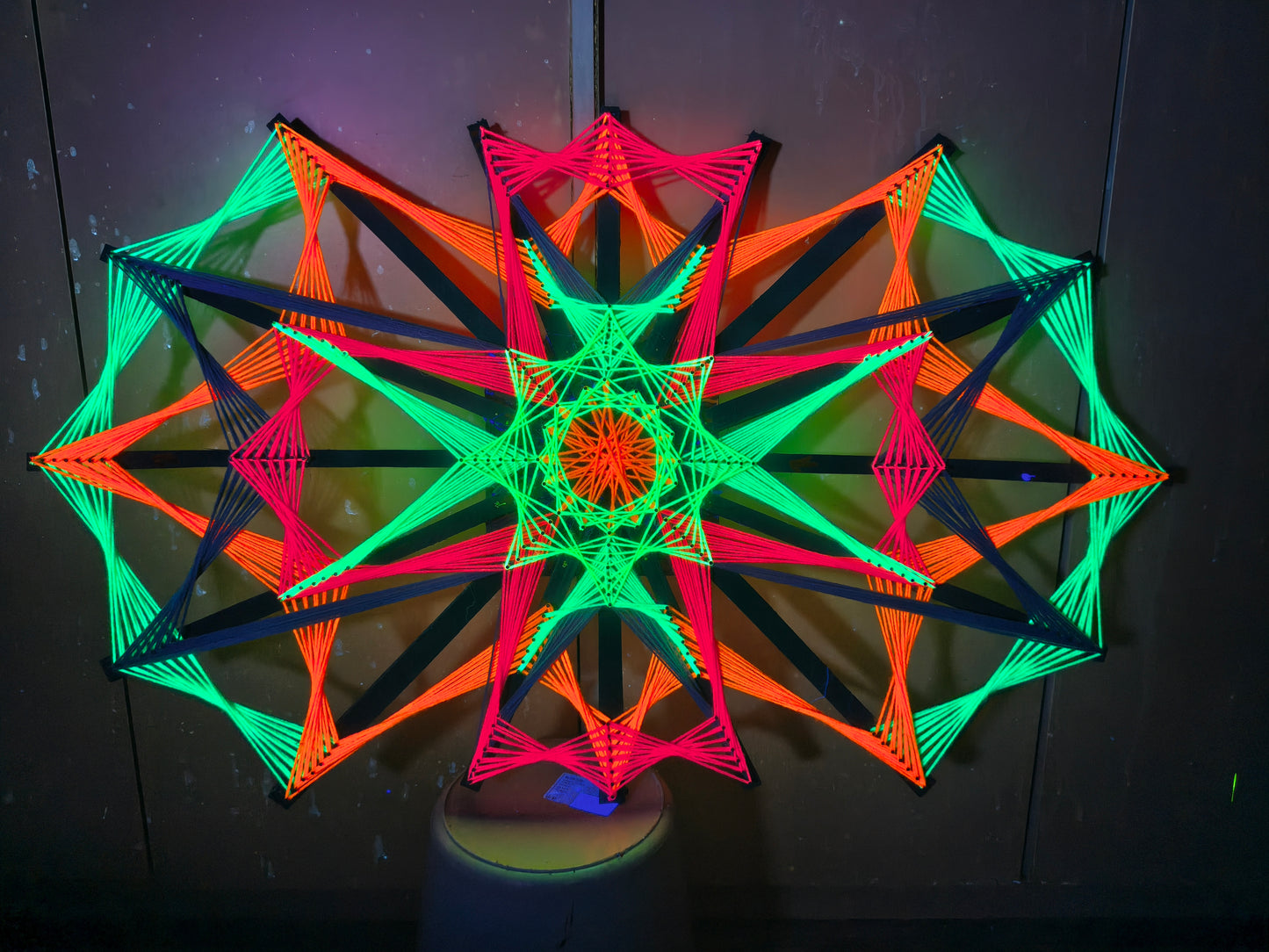 Colorsun by Psybell string art knitted on wooden slats, handmade geometric artwork using colorful threads and natural wood base