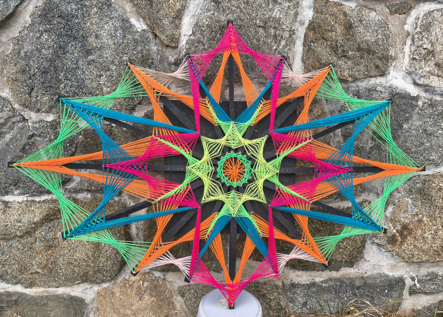 Colorsun handmade string art on wooden slats, precise geometric pattern created with colorful threads on layered wood surface