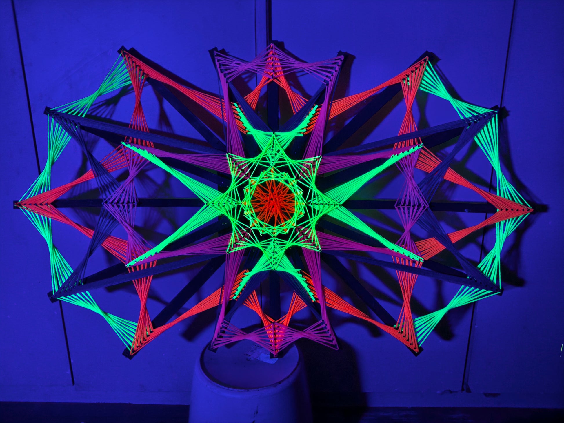 Colorsun #25 UV string art mandala glowing in neon rainbow colors under blacklight, handmade circular geometric wall art