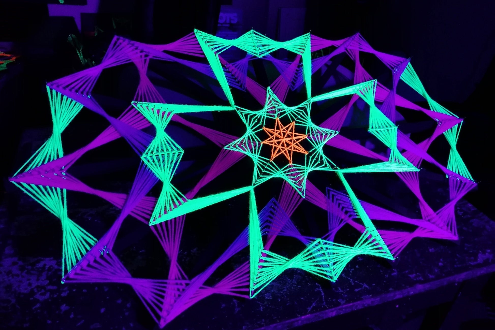 Colorsun geometric string art knitted on wooden slats, handmade wall art with colorful threads reacting to light, modern fiber art design