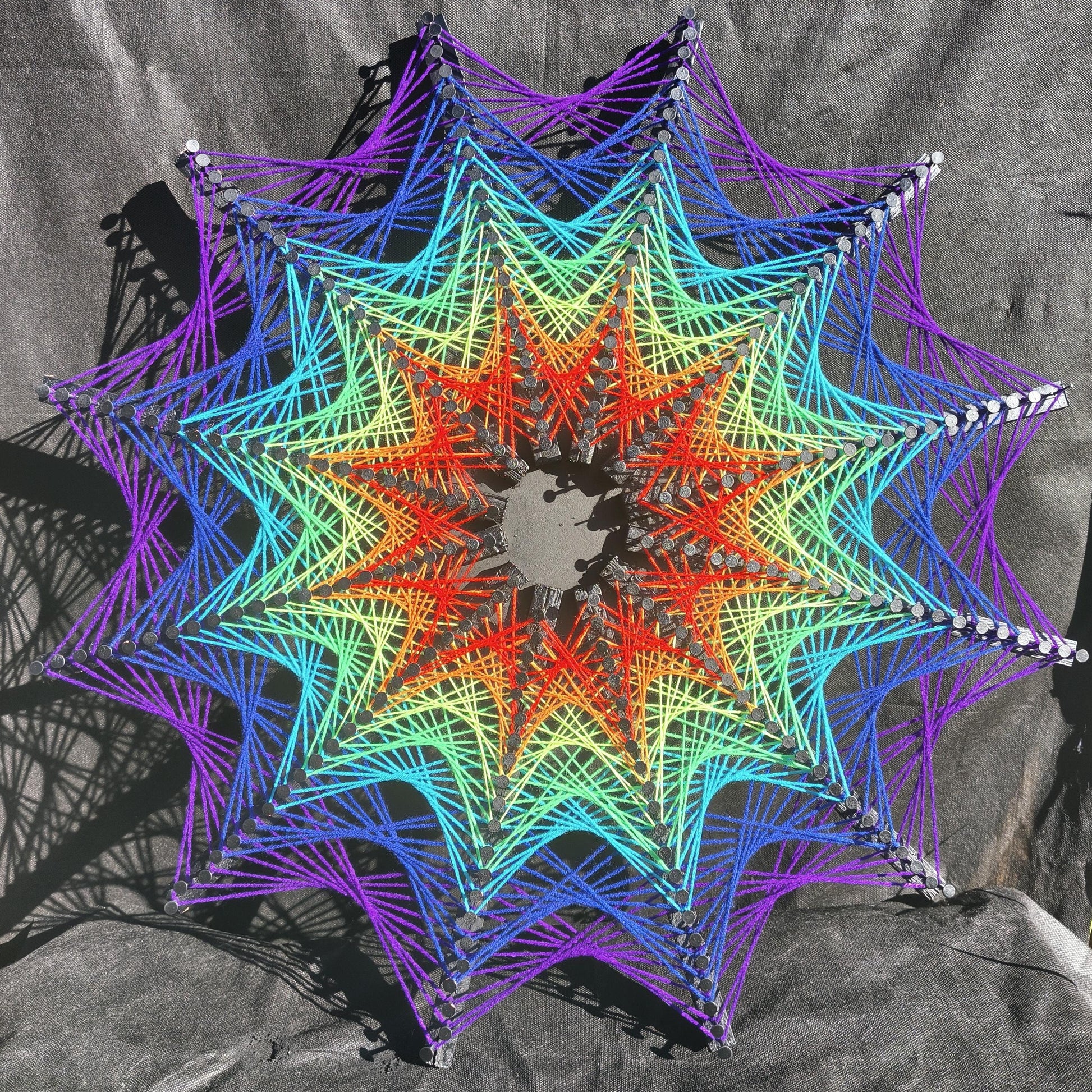 Cosmic Stargate geometric string art with star-shaped pattern, colorful threads on black background, handmade wall art Psybell