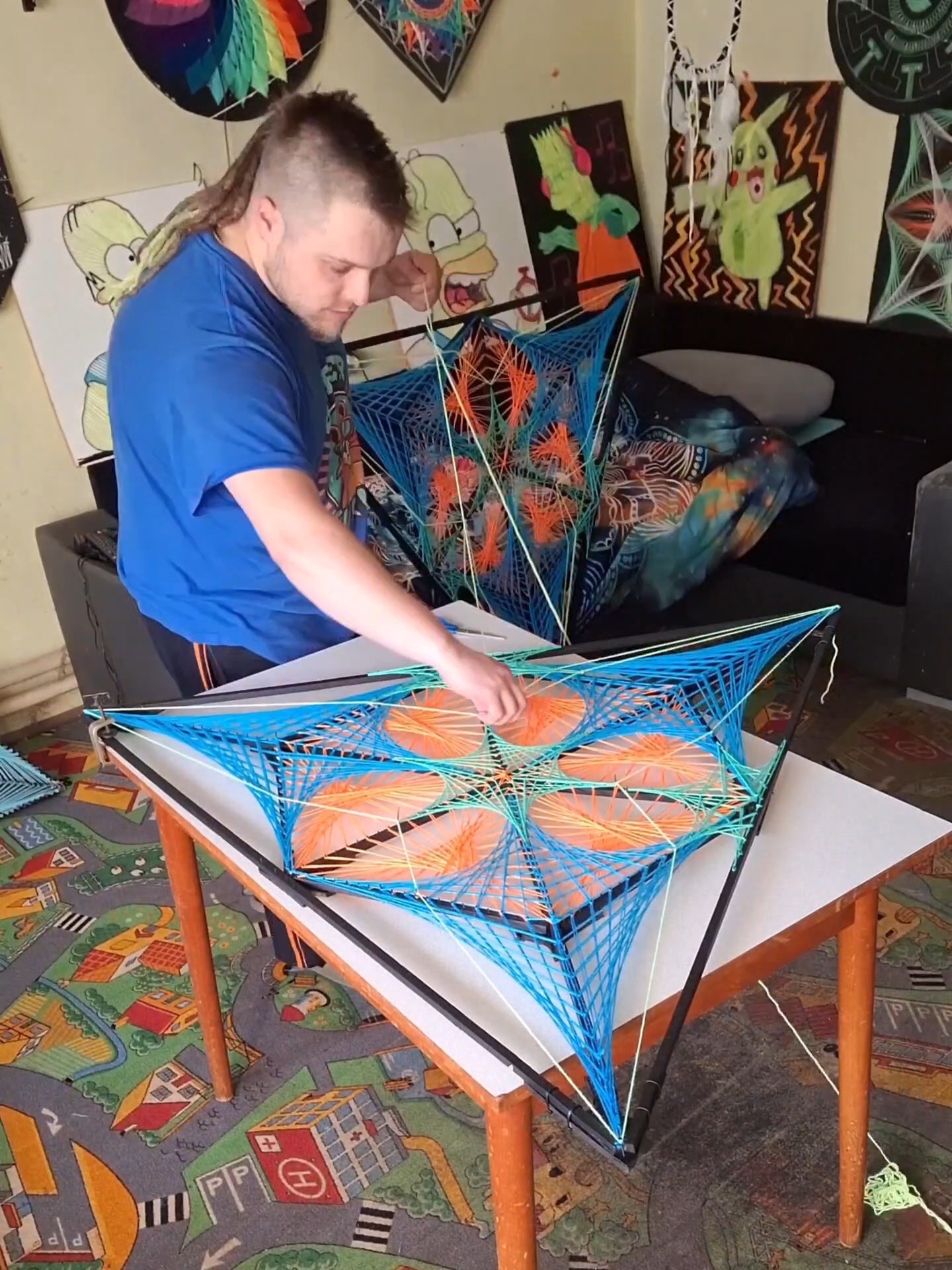 Artist Ivan Samuelčík creating geometric string art Tripple Double Mitsubishi by hand, stretching threads on triangular wooden frame