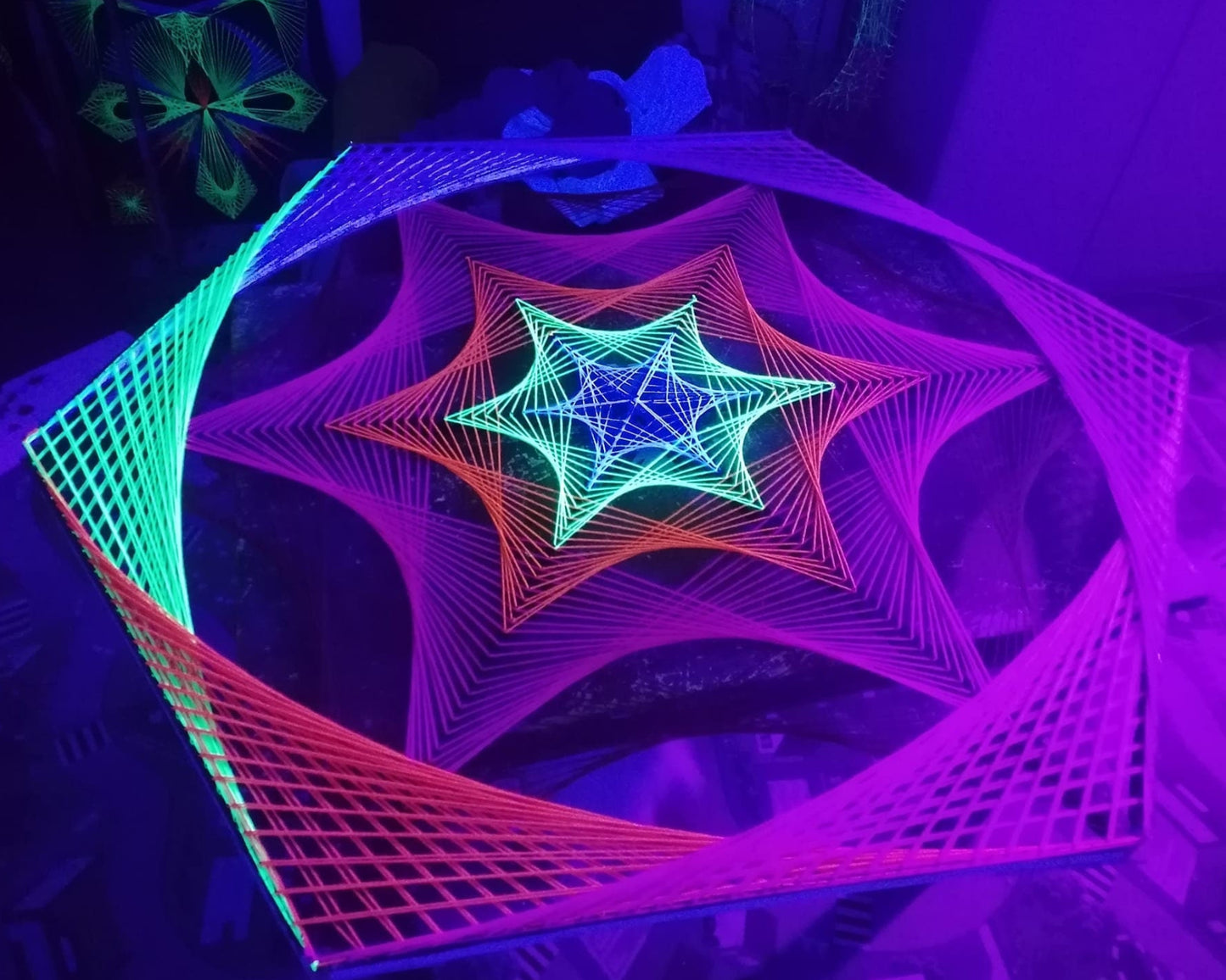 Geometric hexagon string art with colorful star pattern, UV glow fibers stretched on nails, psychedelic wall art
