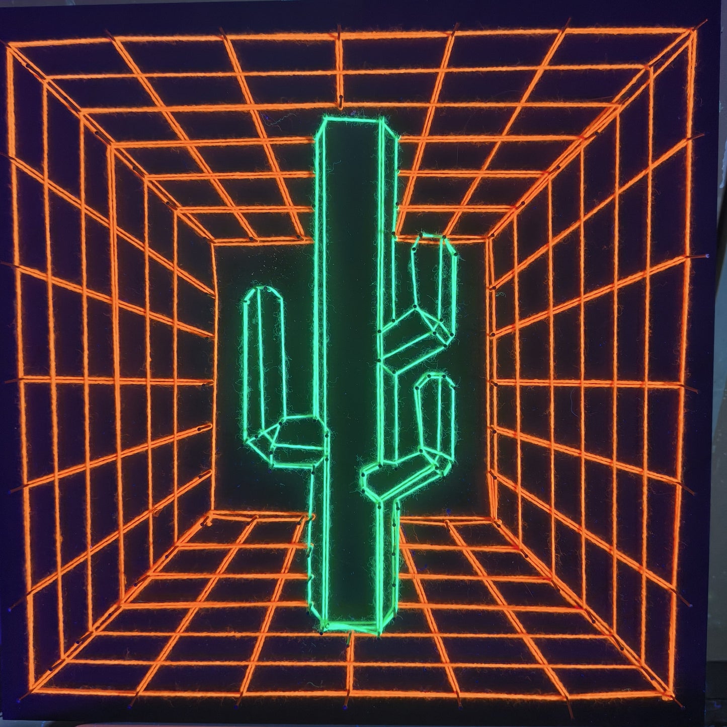 handmade UV reactive string art cactus with geometric perspective grid background, neon green and orange threads, glowing under ultraviolet light, by Psybell
