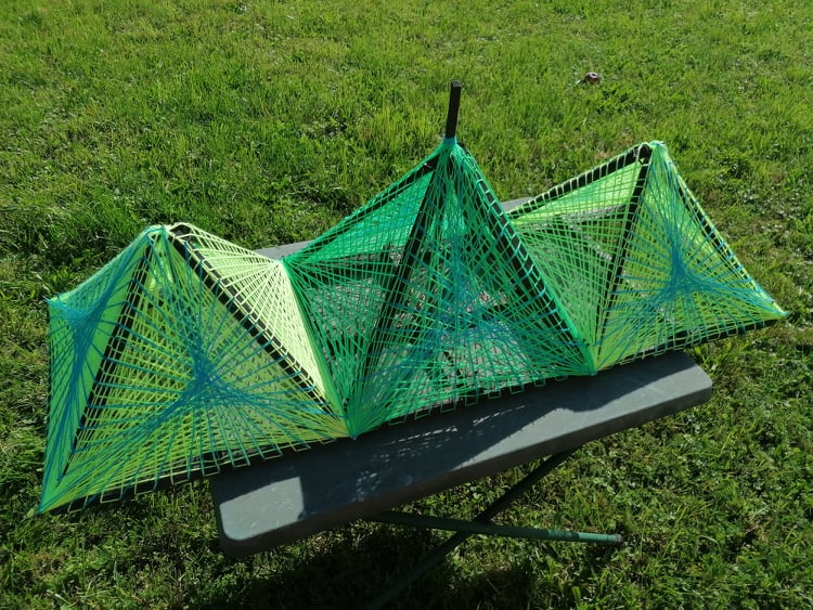 Triple green string art pyramids, handmade 3D geometric installation with neon threads, Psybell string art sculpture