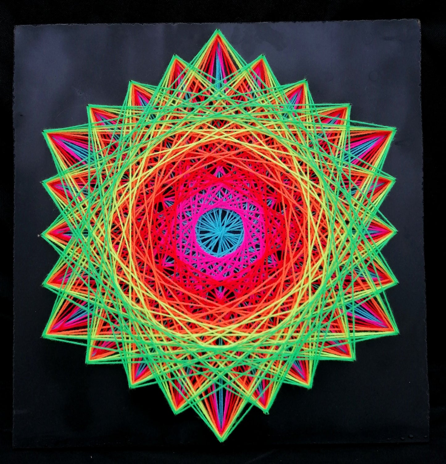 handmade geometric string art with symmetrical hexagon mandala pattern, rainbow multicolor threads on dark background, by Psybell
