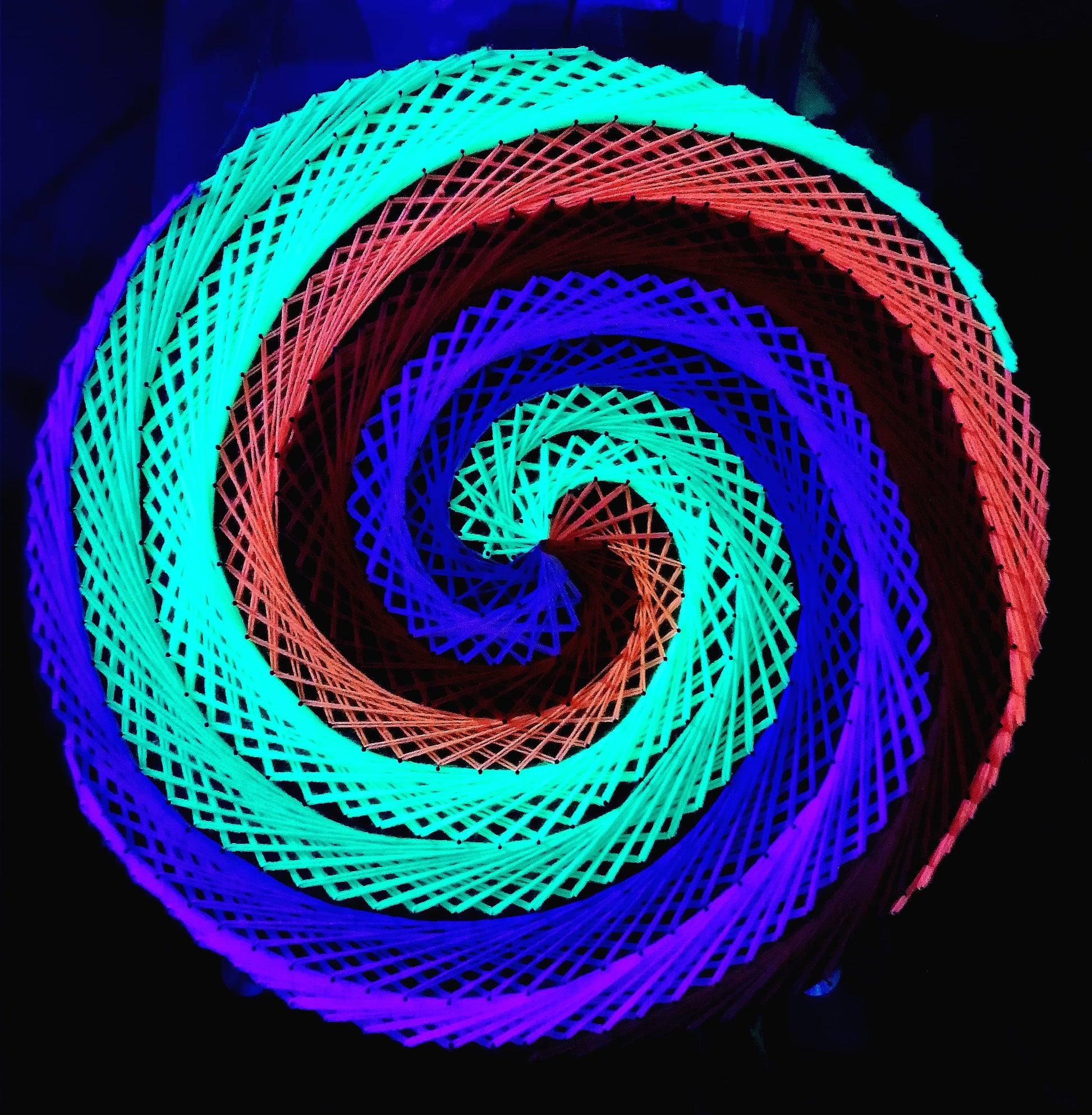 handmade string art circle with symmetrical geometric pattern, rainbow colors design, made from synthetic acrylic threads, by Psybell
