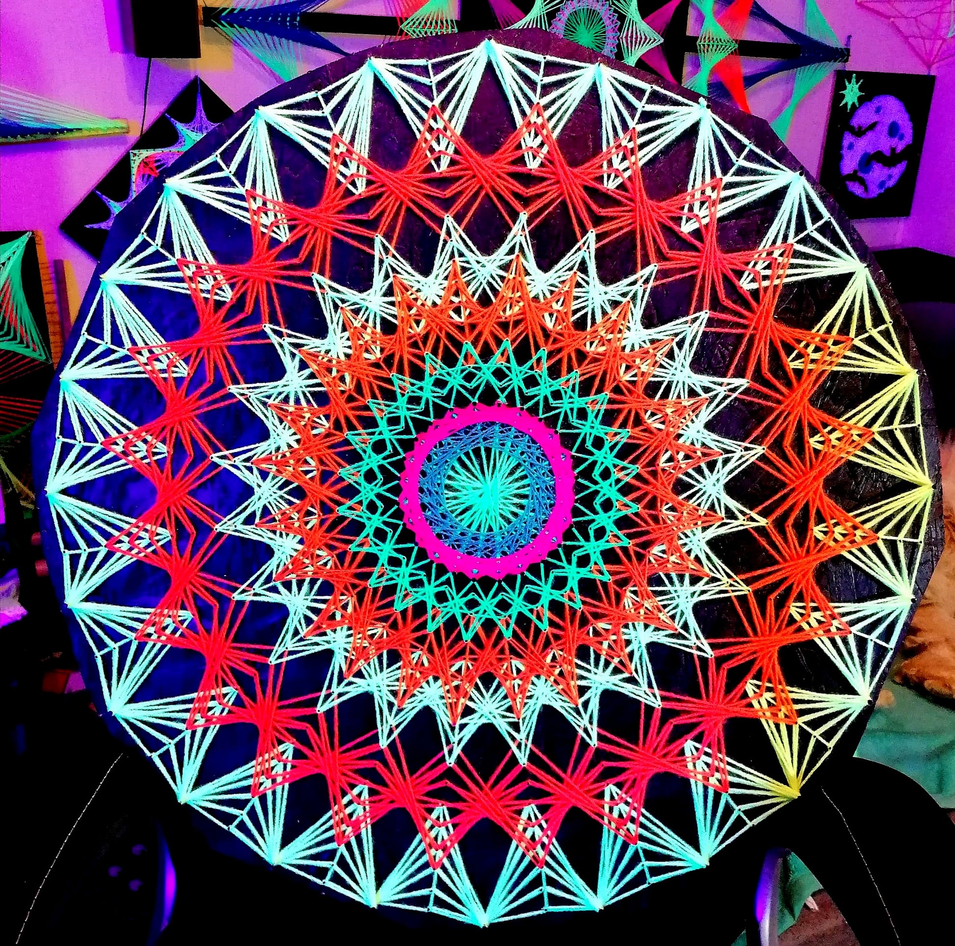 Sun Mandala under UV light – glowing neon geometric string art wall decoration for psytrance interior