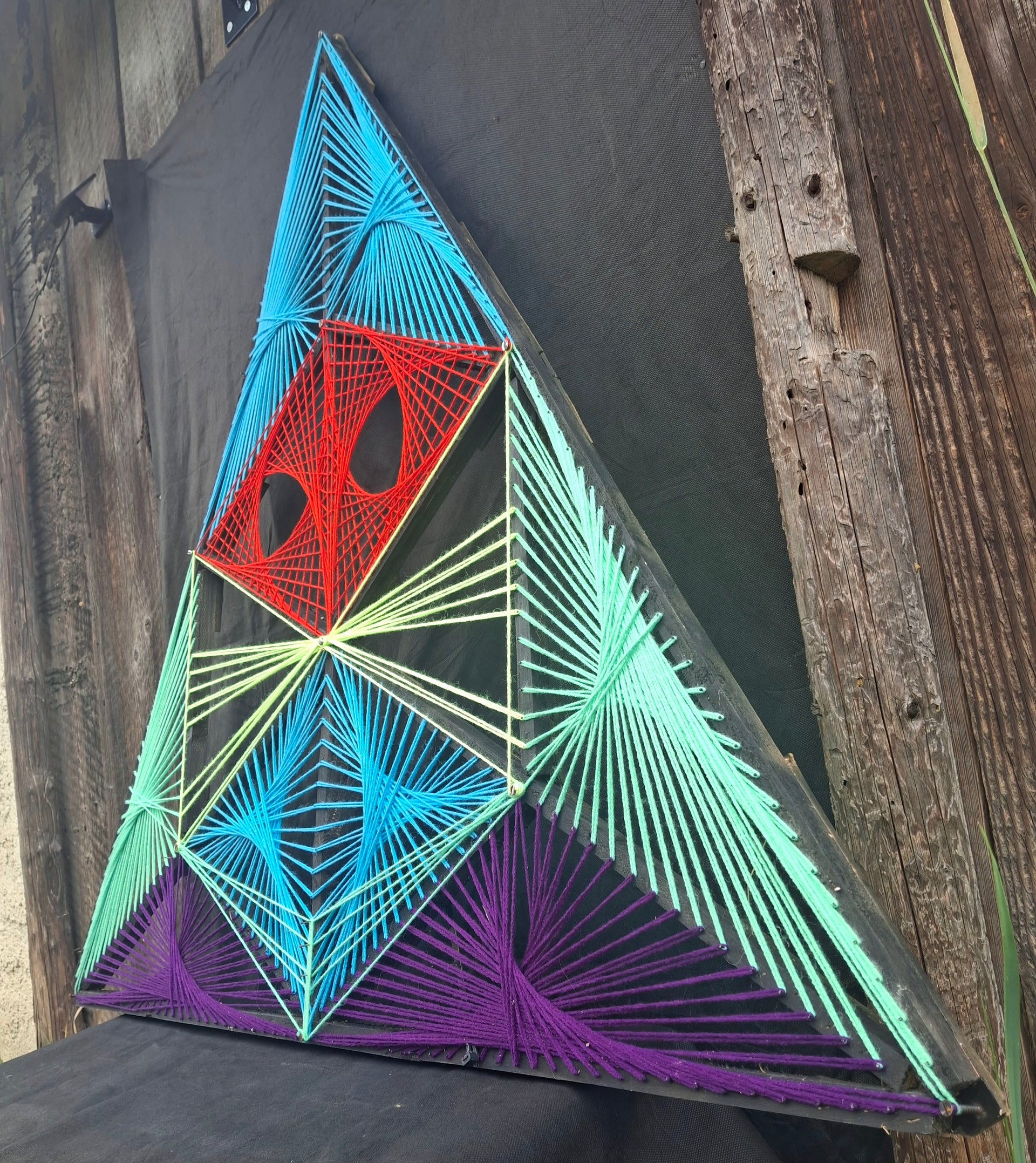 Load video: Time-lapse video of creating Triad Sentinel string art, handmade geometric thread weaving process on wooden board, Psybell studio