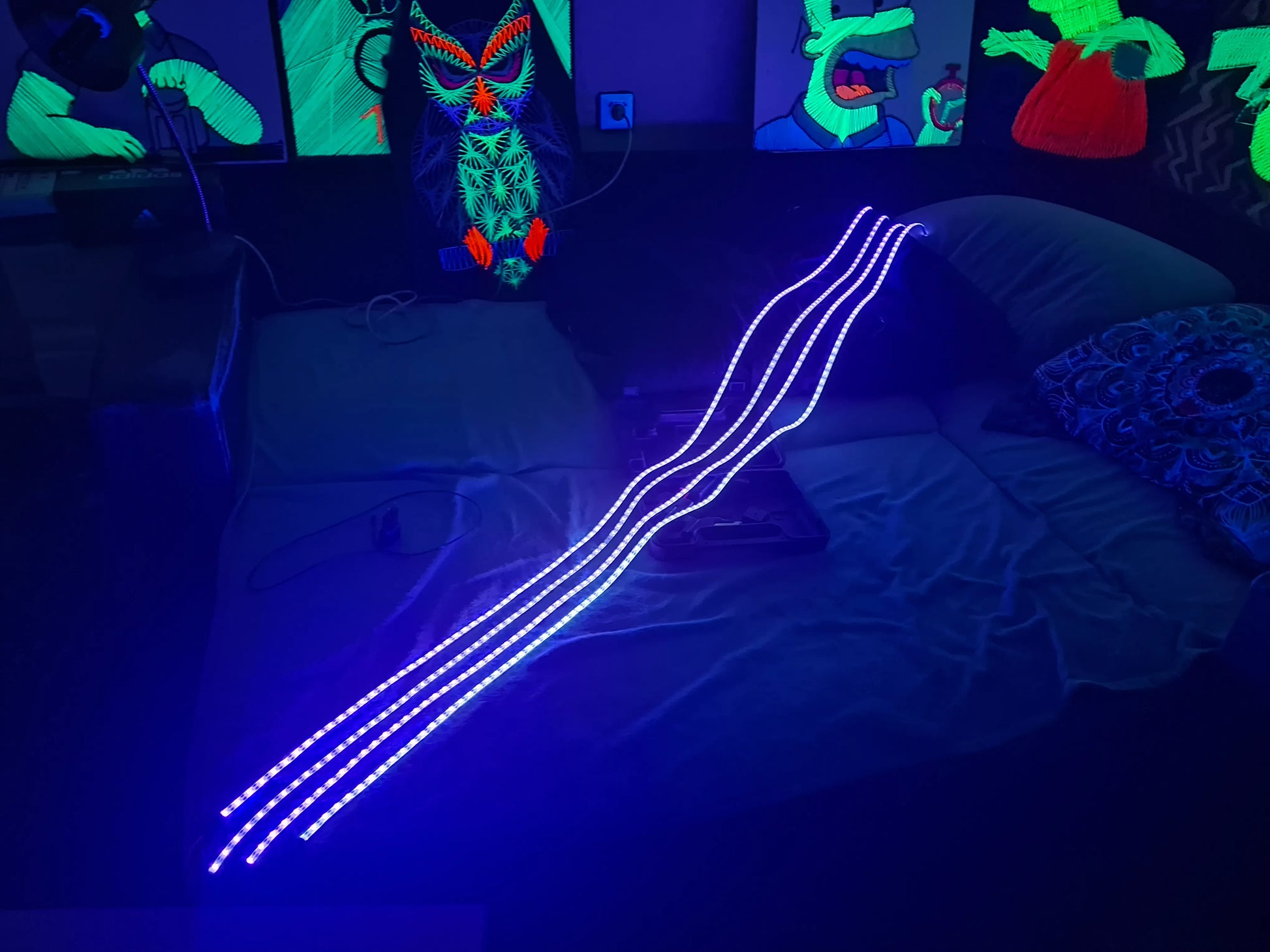 Neon lights on a bed with colorful wall art in the background