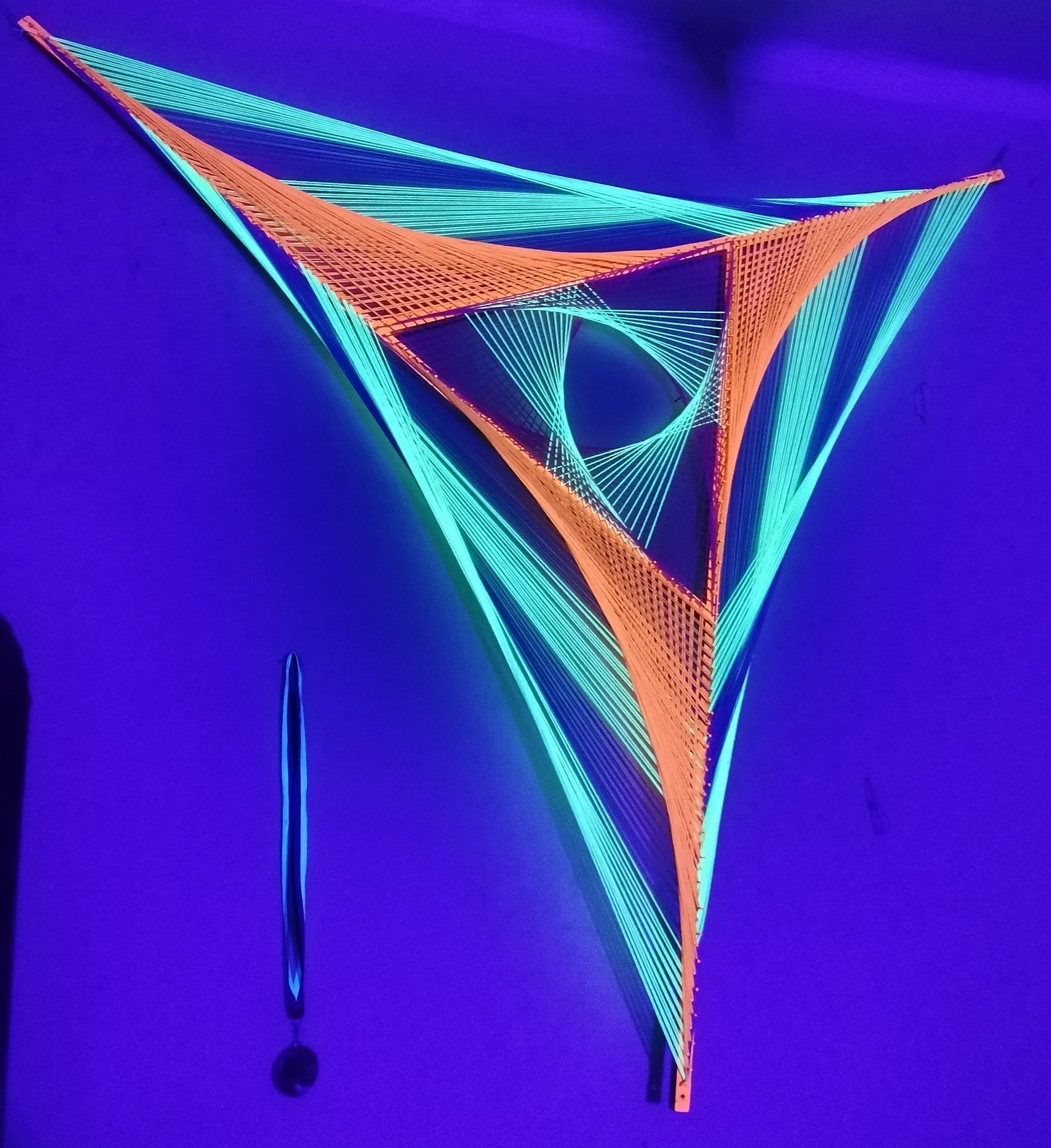 Windmill string art on wooden slats, handmade geometric wall art with UV reactive threads, triangular windmill pattern glowing under UV light