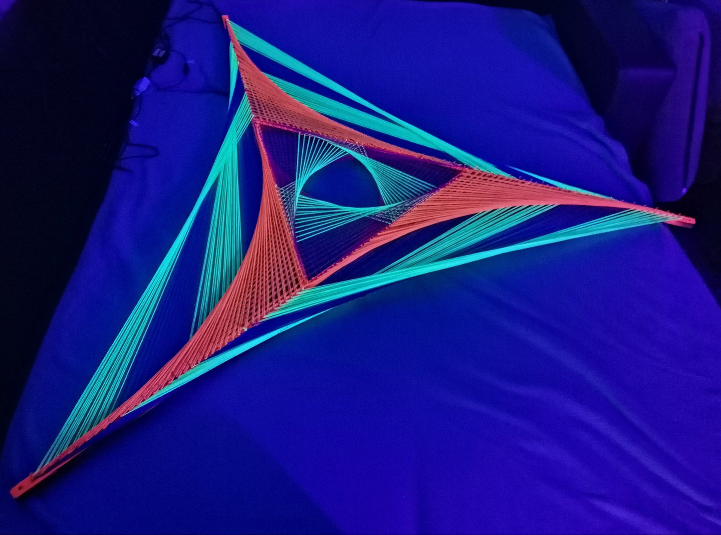 Windmill inspired string art on wooden slats, abstract geometric wall art with glowing UV threads