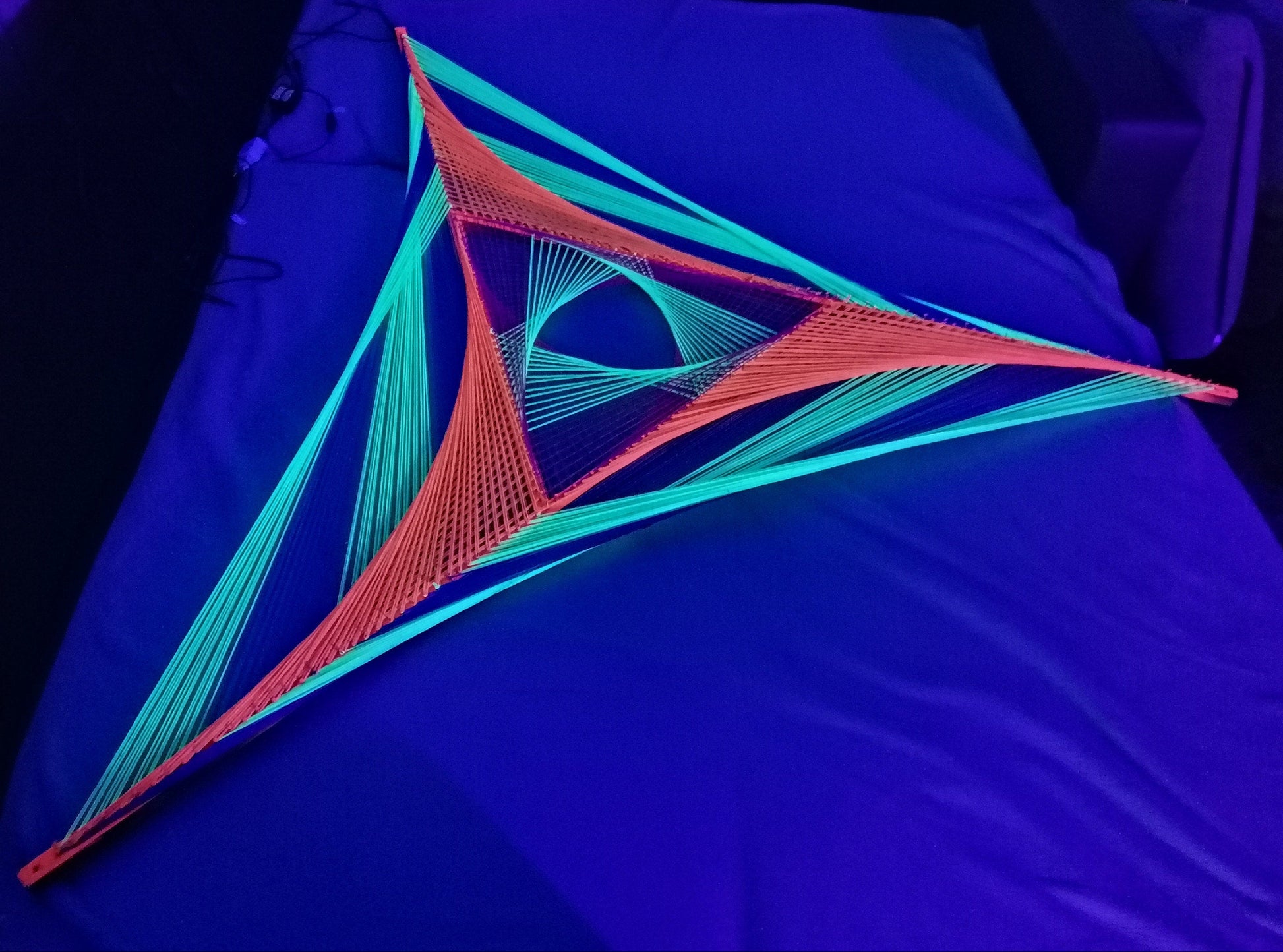 Windmill inspired string art on wooden slats, abstract geometric wall art with glowing UV threads