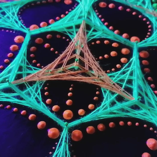 UV glow macro video of dotted mandala string art “Transformer” by Psybell under blacklight showing colorful thread geometry