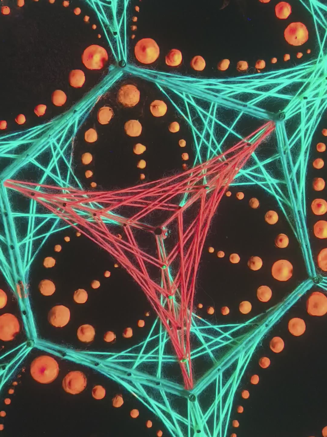 Macro video of dotted mandala string art “Transformer” by Psybell showing colorful thread geometry and dotted pattern