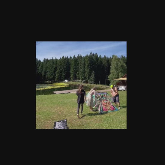 Building a large Psybell string art pyramid at Digital Forest festival, collaborative installation process captured on video, handmade geometric pyramid assembled with neon threads