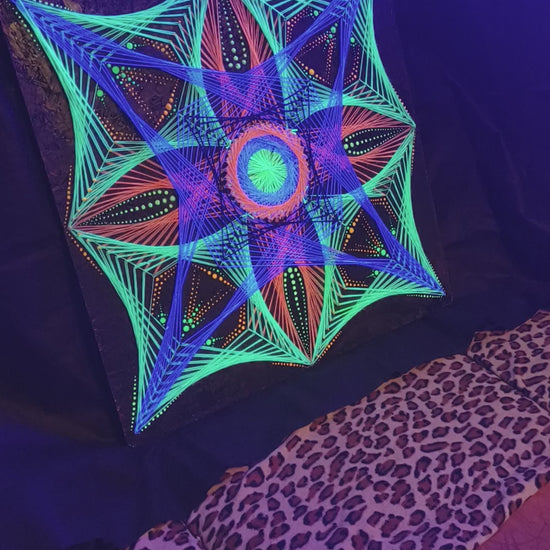 Macro UV glow video of geometric string art mandala “Aura Flow” by Psybell under blacklight showing fluorescent threads and dotted mandala details