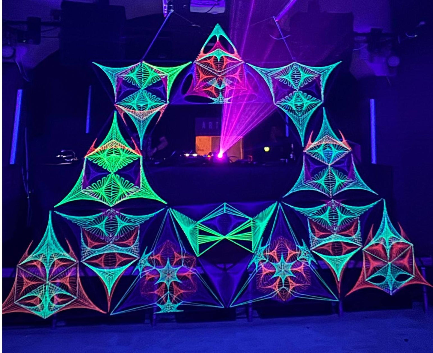 UV reactive string art stage decoration by Psybell at Artbar Club in Brno 2025, psychedelic geometric installation glowing under blacklight.