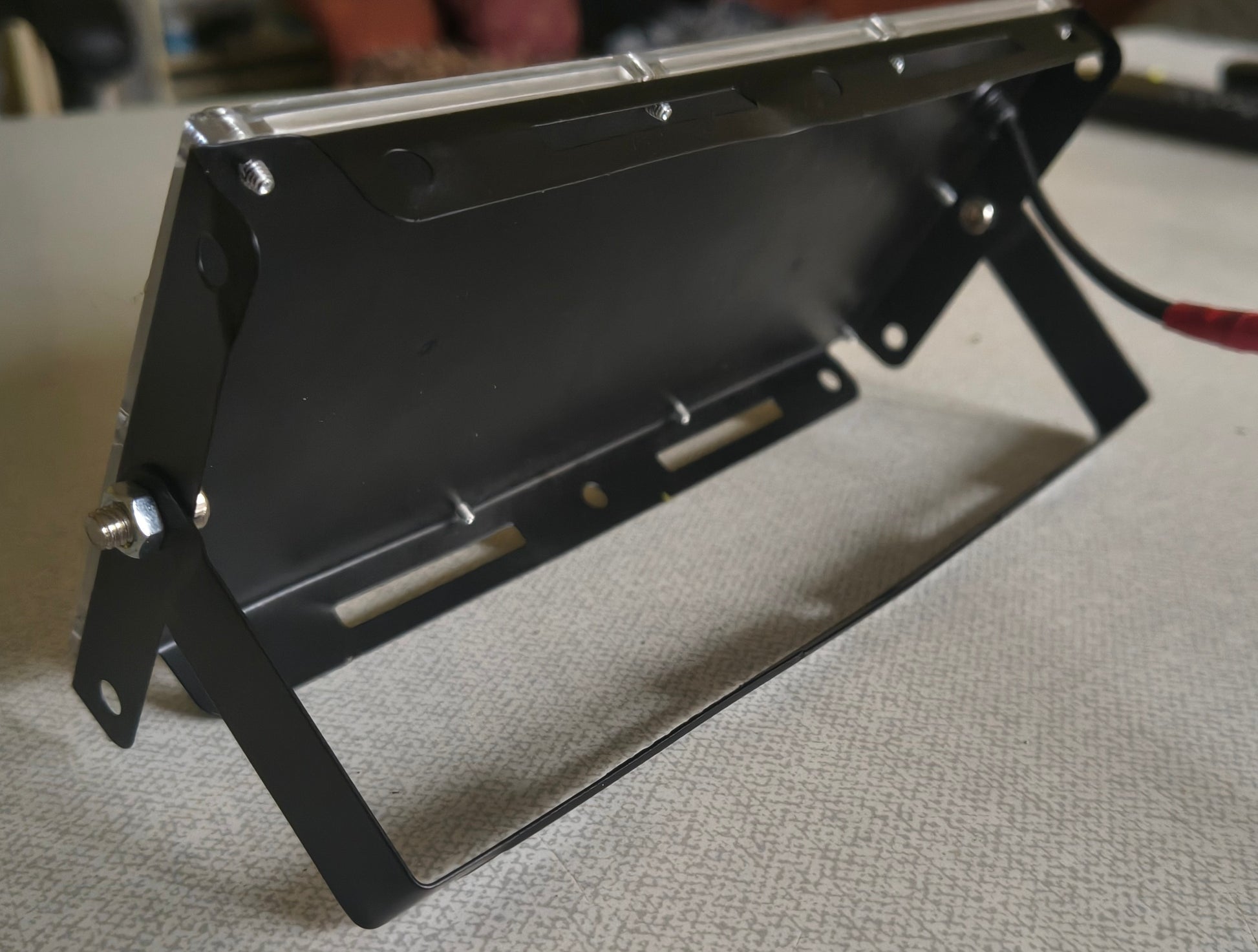 Rear view of 395nm UV LED blacklight floodlight showing metal mounting bracket and power cable used to illuminate Psybell UV reactive string art