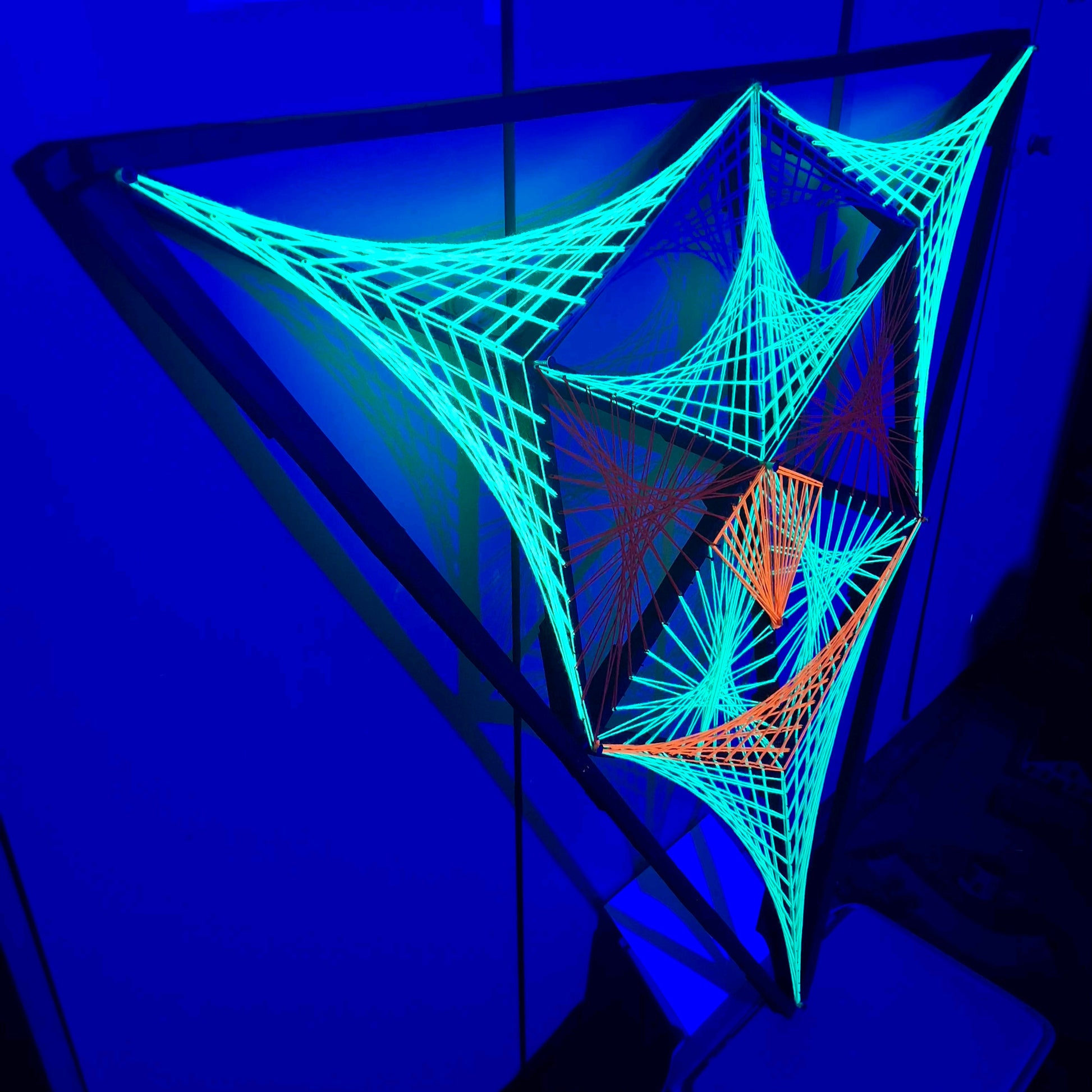 UV reactive geometric string art sculpture Alien Hunter by Psybell glowing under blacklight