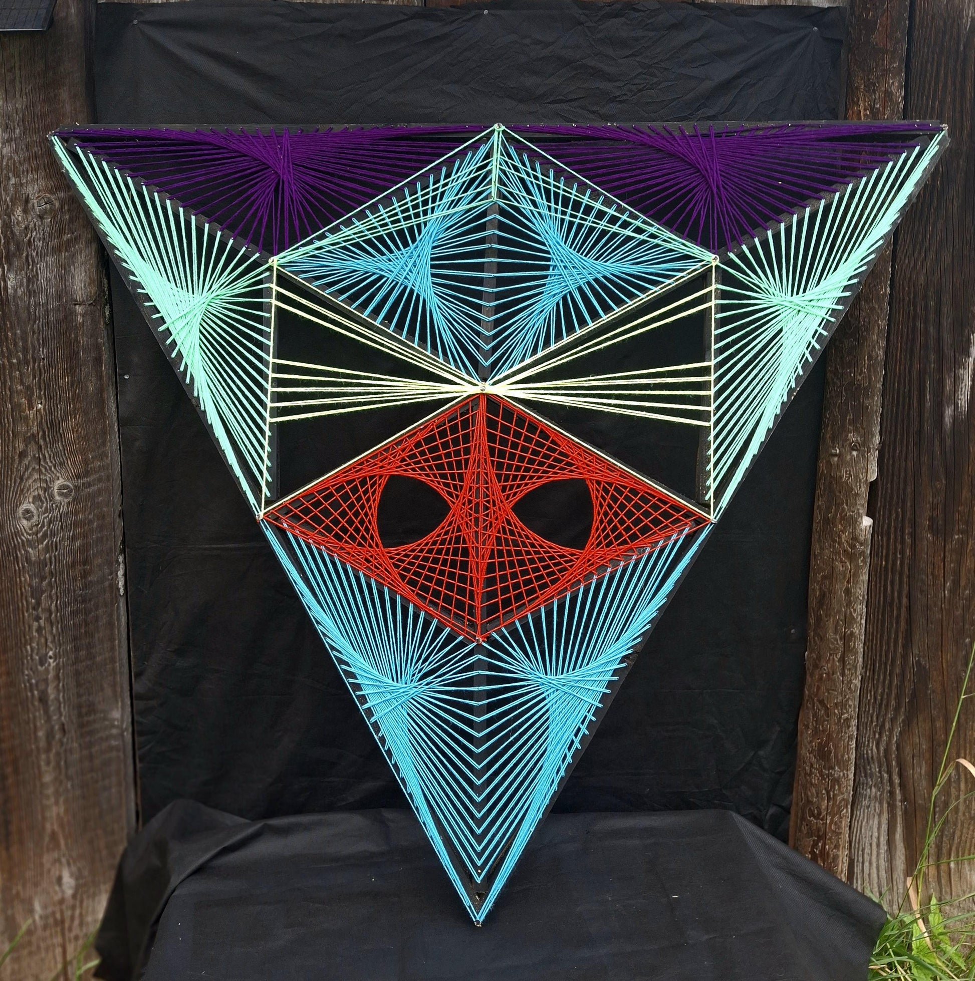 Aliens Sentinel geometric string art wall sculpture by Psybell displayed on dark background