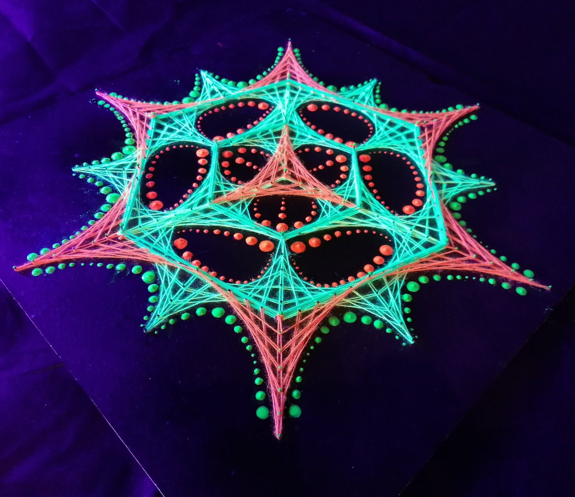 UV reactive dotted mandala string art design “Transformer” by Psybell glowing on dark background